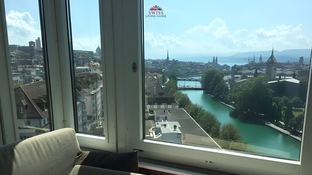 Modern hotel room in Zurich with large windows offering city or lake views.